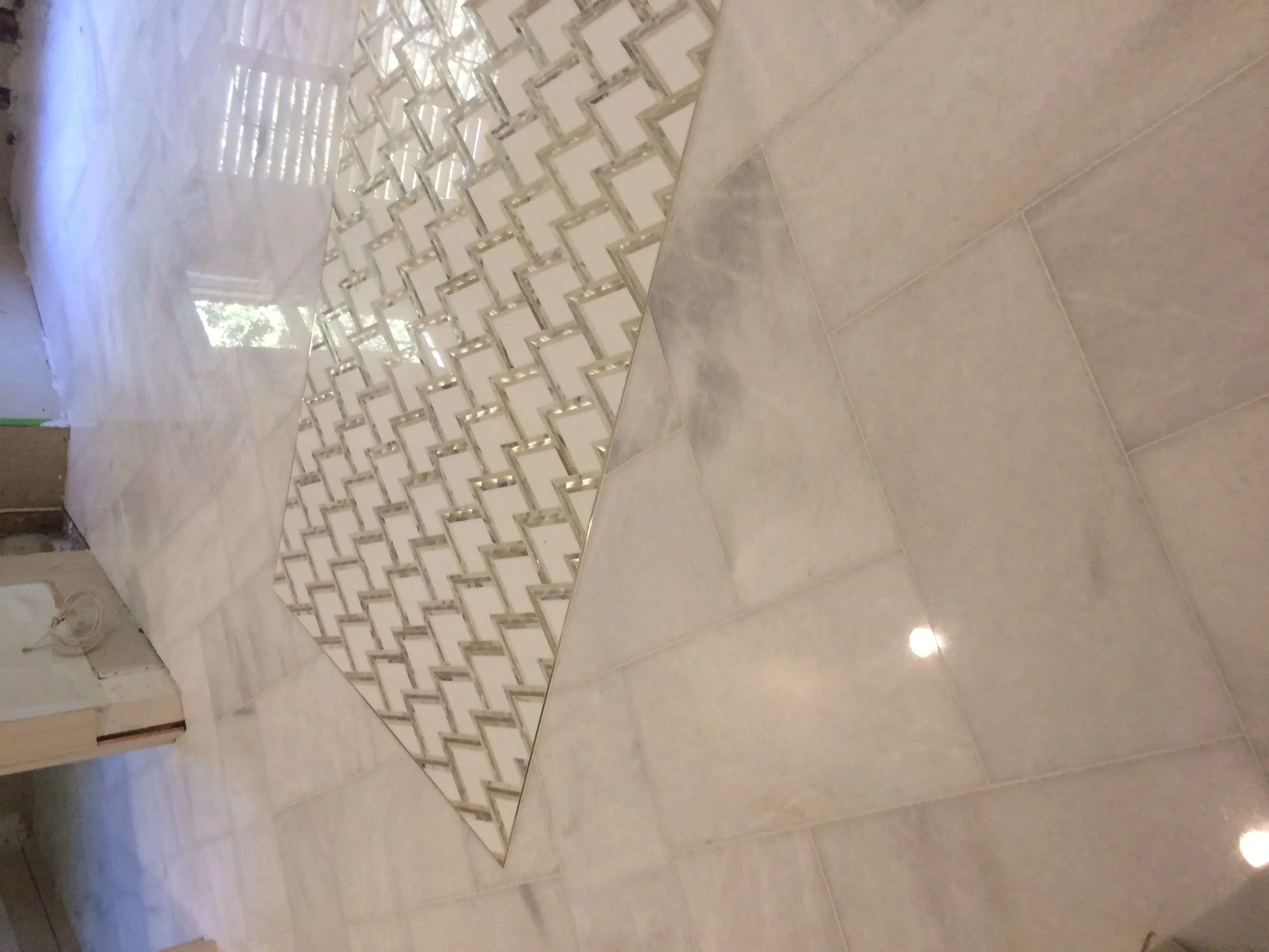Bathroom with large porcelain tiles and herringbone pattern accent wall installation