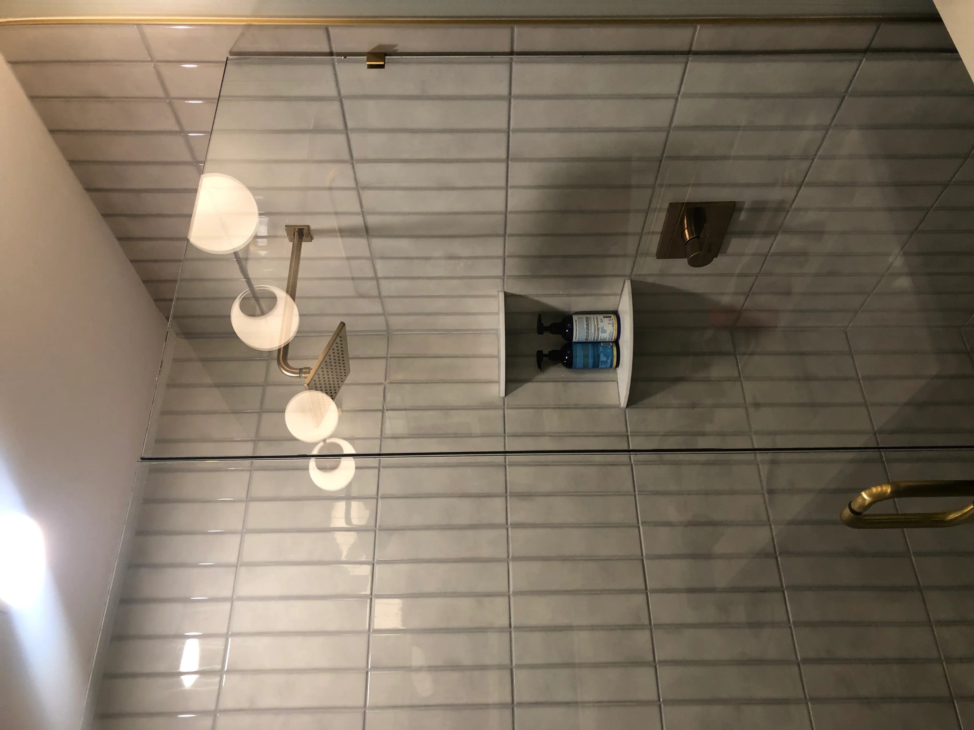 Modern bathroom with gray subway tile walls, recessed lighting, and brushed nickel fixtures