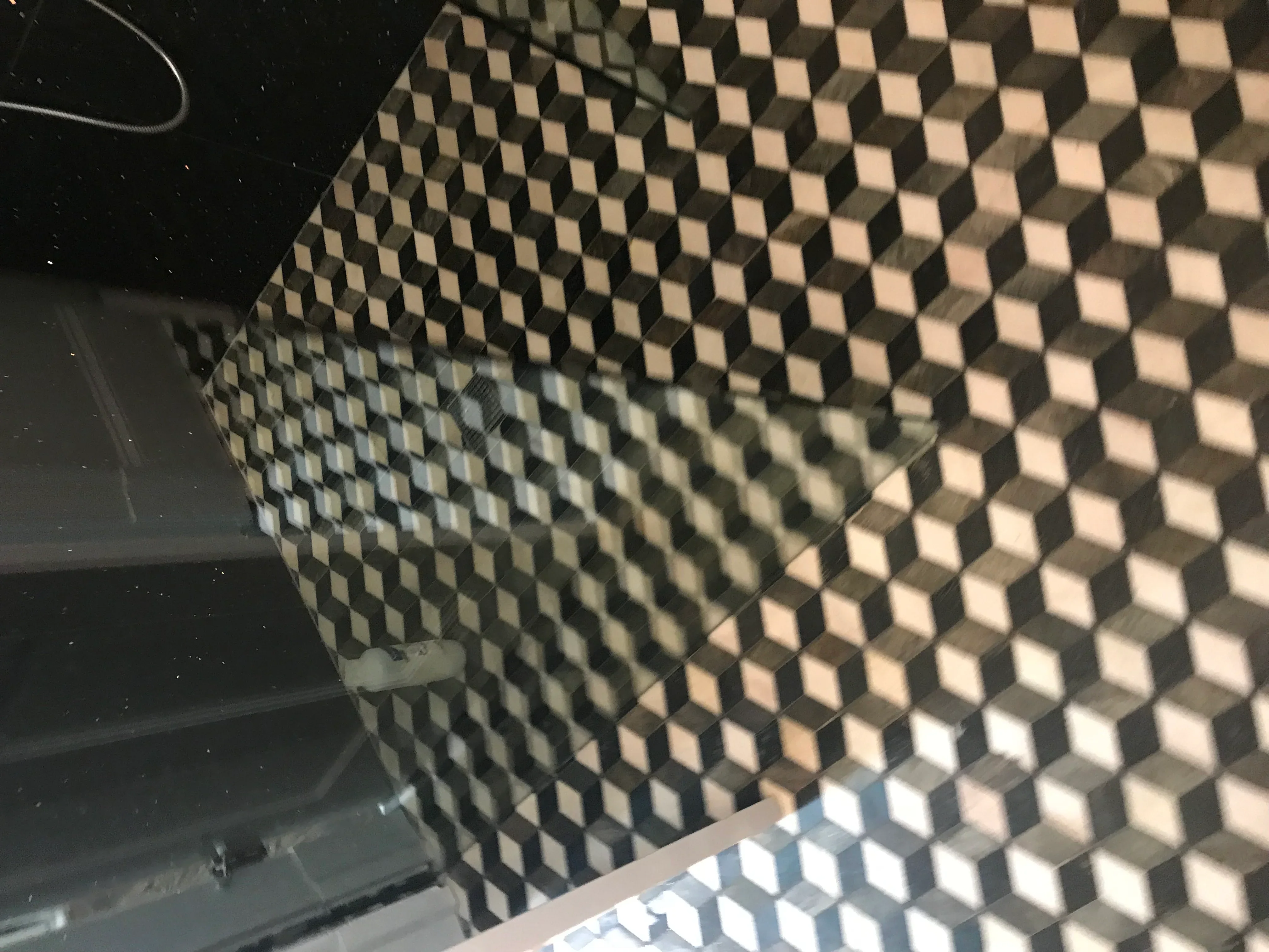 3D geometric cube tile pattern in cream and charcoal installed on bathroom wall