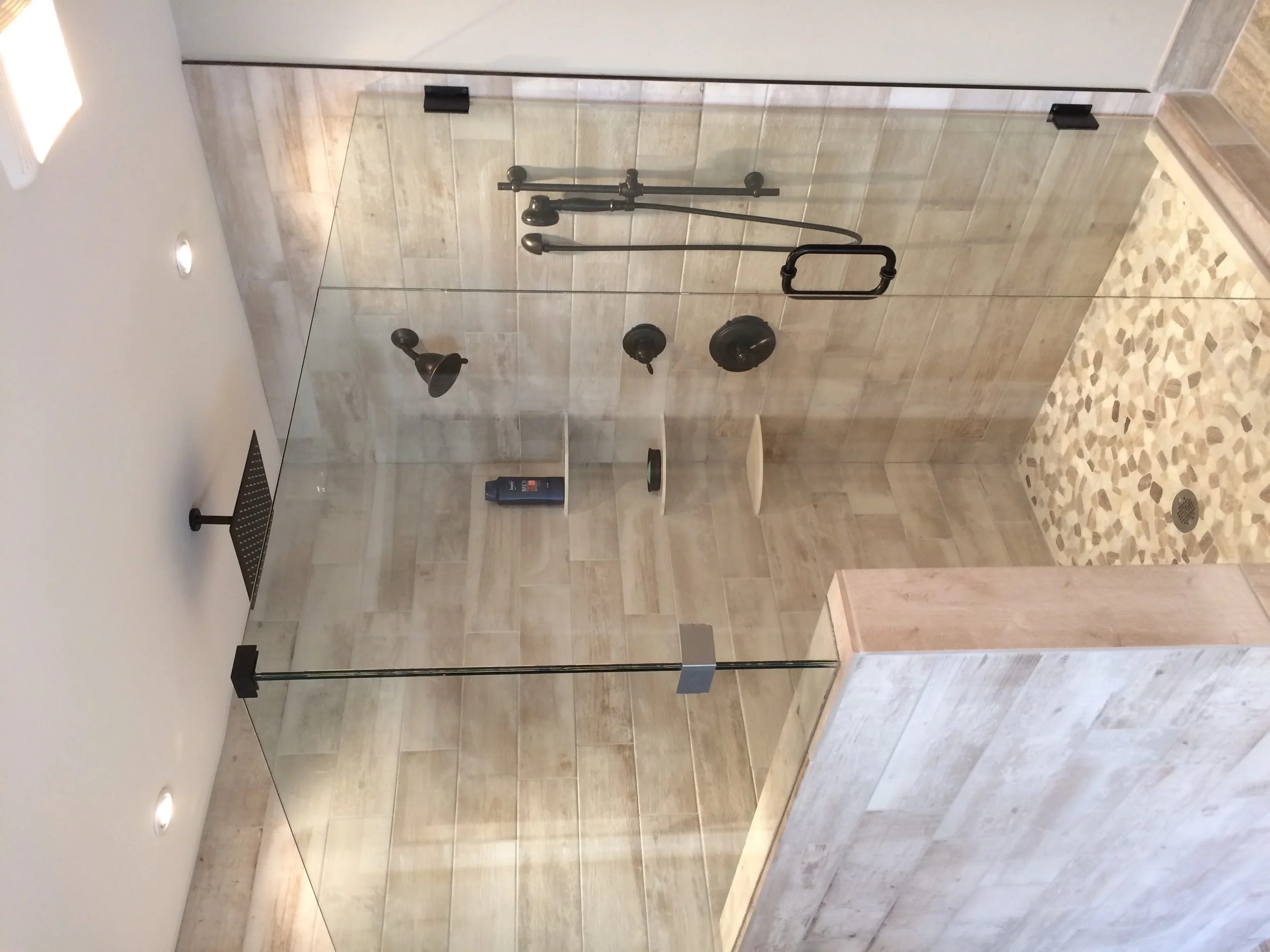 Overhead view of luxury shower with frameless glass doors and bronze fixtures