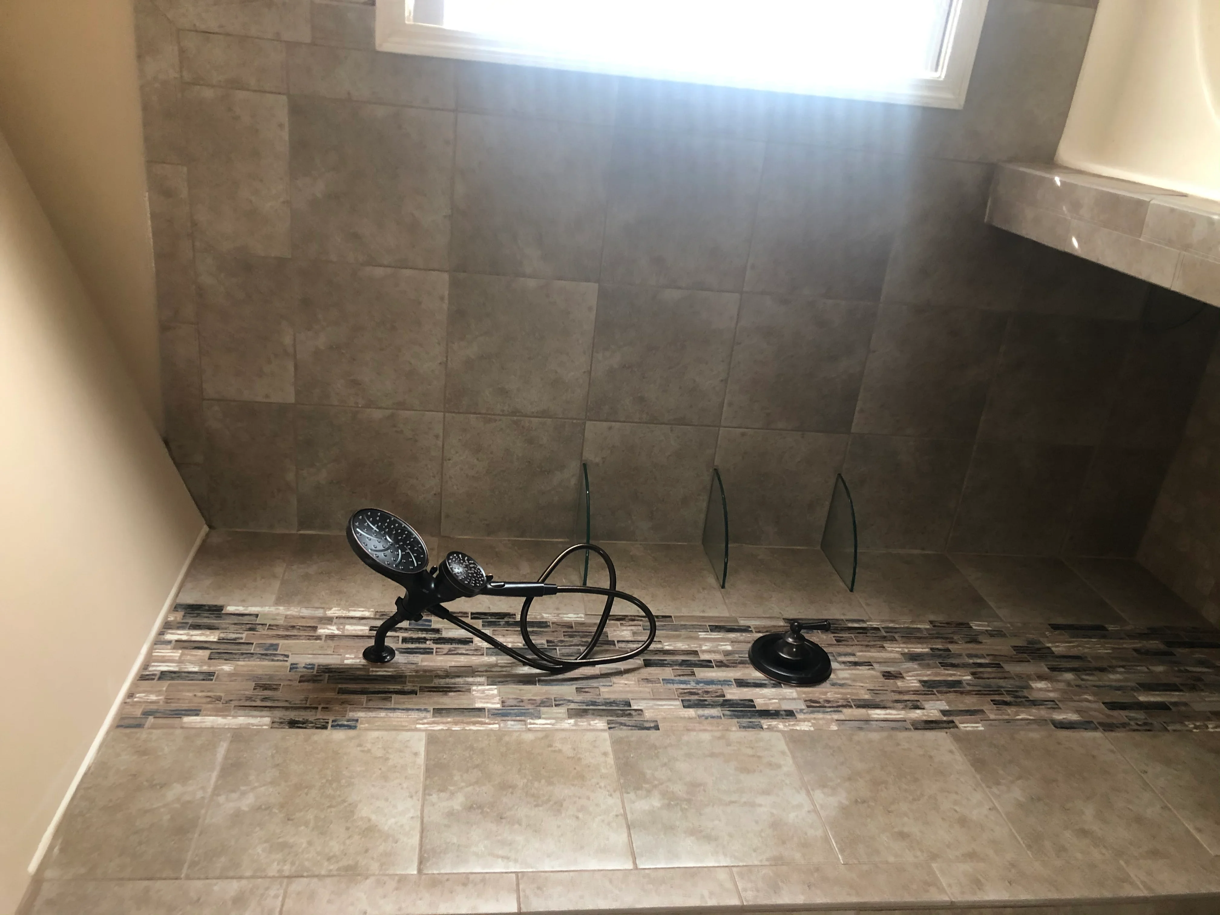 Bathroom with gray porcelain wall tile and mixed-pattern floor tile installation