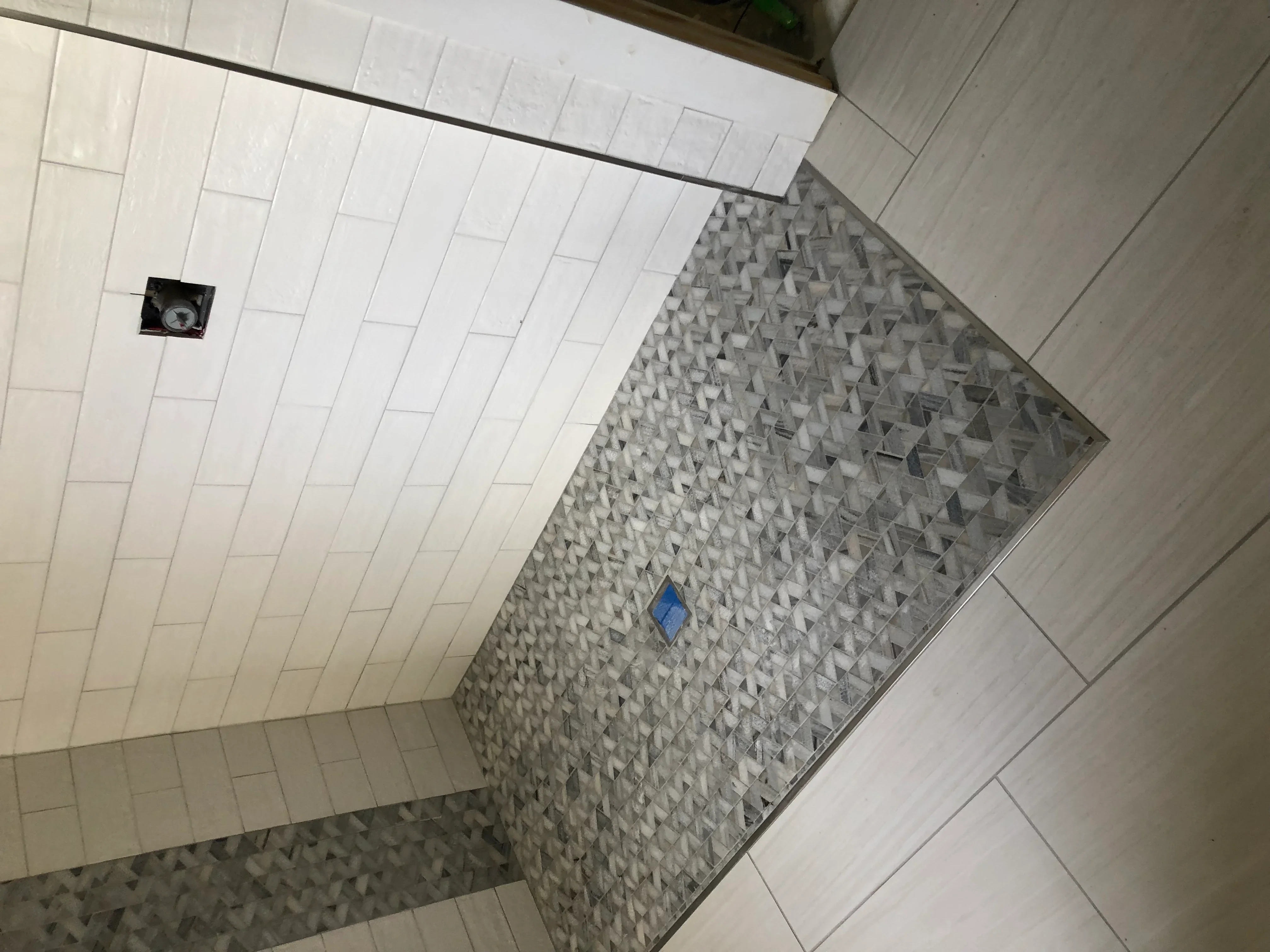 Modern bathroom shower with white subway tiles and textured gray 3D accent wall